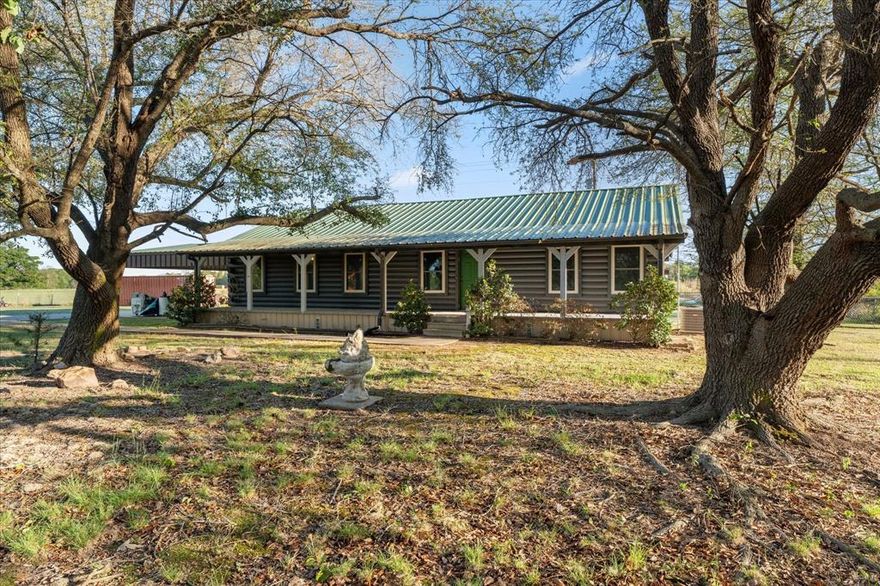 Log Cabin - 5 Acres - No Restrictions. This well cared for nearly 1600 sq ft 3 bedroom, 2 bathroom log home sits on 5 acres in northern Titus county! The living area offers open space and with fresh paint and vinyl plank flooring throughout. The split bedroom layout offers two spacious spare bedrooms with a hall bathroom that is handicap accessible and the primary suite offers a private ensuite bath with walk in closet. A cozy rear facing kitchen with connected laundry offers great storage and peaceful views! The windows and back sliding doors were recently replaced. Outside you find front and back porches, a metal roof, 2 large car carport with an entrance ramp for accessibility, Conex storage container with water and power, dual driveways, a fenced in back yard and 5 acres of pasture with a pond in the back. This home is move in ready! Call today for a private showing!
