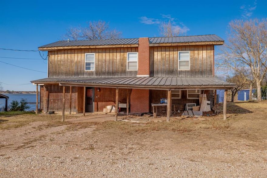 Enjoy lakefront living in this 4-bedroom, 3-bath, two-story home full of classic ’70s character and timeless appeal. Set right on the water, the home offers sweeping lake views and an abundance of natural light throughout, with windows positioned to take full advantage of the scenery from nearly every room. The living room is anchored by a large brick fireplace, creating a warm and inviting space for gatherings and cozy evenings. Just off the main living areas, the sunroom provides a peaceful place to relax year-round, complete with a wood-burning stove and beautiful views of the lake. The multi-level layout offers flexible living spaces, perfect for both entertaining and everyday living, while the home’s original charm adds personality you don’t often find today. Step outside and enjoy easy lake access along with a shared covered dock—ideal for boating, fishing, or simply unwinding by the water. Whether you’re searching for a full-time residence or a weekend retreat, this lakefront property delivers vintage style, serene surroundings, and memorable lake views from every angle.