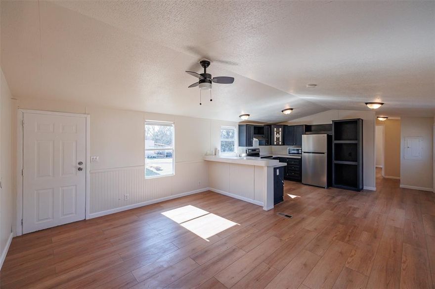 Recently updated single-wide manufactured home for sale in the community of Sky Harbour. 2 bedroom, 2 bath, 896 square feet, built in 2006. Metal siding, metal roof, and located on a very roomy lot with a seasonal creek behind the home. Open living area, updated kitchen, breakfast area, split bedrooms. Recent updates are new vinyl flooring throughout, fresh paint inside, updated kitchen, both bathrooms updated. Primary bathroom has a wonderful oversize walk in shower, elegant cabinets, double sinks, and a very modern look. Kitchen has refrigerator, cooktop stove, dishwasher, and microwave. Front deck, large walk out covered deck off the primary bedroom, and a third exit door with a walk out perch. Includes a nice 1 car metal carport. Chain link fenced backyard. Great location off Highway 51 with close proximity to Granbury and Weatherford. HOA offers Lake Granbury access, community pool, community park, community fire department, and more!