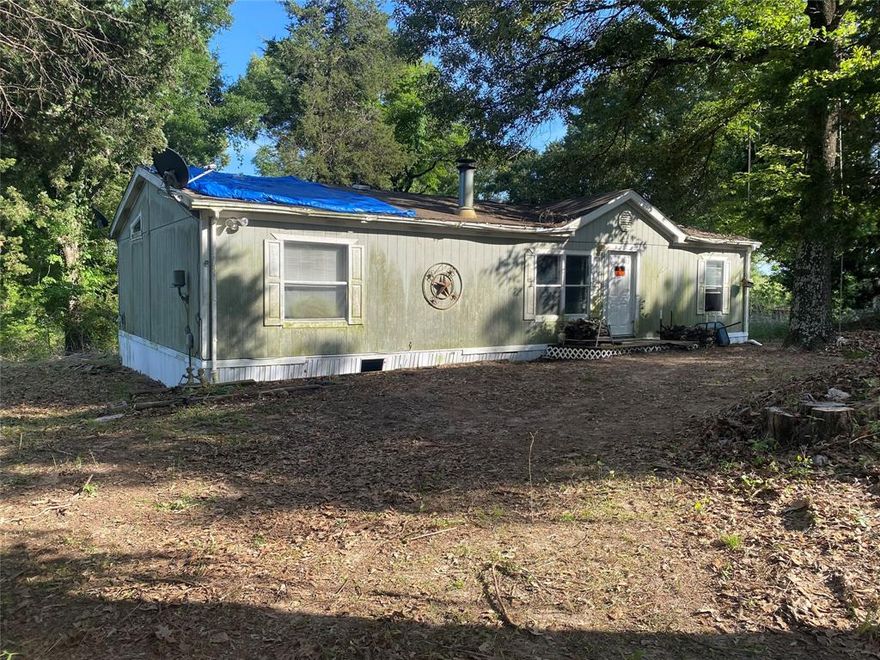 This four bedroom doublewide sits on 3 acres and sits about a mile from the frontage road of interstate 20.  It is a fixer upper that is in need of an AC unit, roofing, flooring and appliances.  The main bedroom is on the opposite side of the home.  The utility room is a nice size that can accomodate a freezer or used as a mud room style.   It is located in Van school district; however, their may be a possibility to attend Canton and Grand Saline schools. Come roam and enjoy the beautiful shade trees and turn this into your new space.