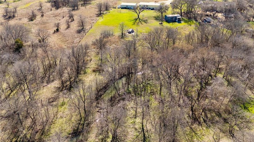 Unrestricted 4.848-Acre Homestead with Creek & Utilities – No HOA or City Taxes!

A true, private sanctuary. Offering the perfect blend of peaceful country living and modern convenience, this unique property is a rare find. Located less than 20 minutes from Tanger Outlets, Lowe’s, and Walmart Supercenter, you get the serenity of the countryside without sacrificing your commute. Take in stunning views from the ridge overlooking your heavily treed acreage, or explore the forest to find your own private, seasonal creek. With no HOA, no City Taxes, and no Deed Restrictions, this is a dream-big property. Whether you want to build a custom barndominium, start a hobby farm, or park your RV, the choice is yours. Save months of time and thousands in permitting and installation costs with septic, water, and electricity already established on-site.

Includes a durable 2-car metal carport with an integrated, enclosed 22x15 storage area for tools and equipment, as well as a separate metal shed.

The existing mobile home is currently livable (sold as-is). Interior pictures available upon request.