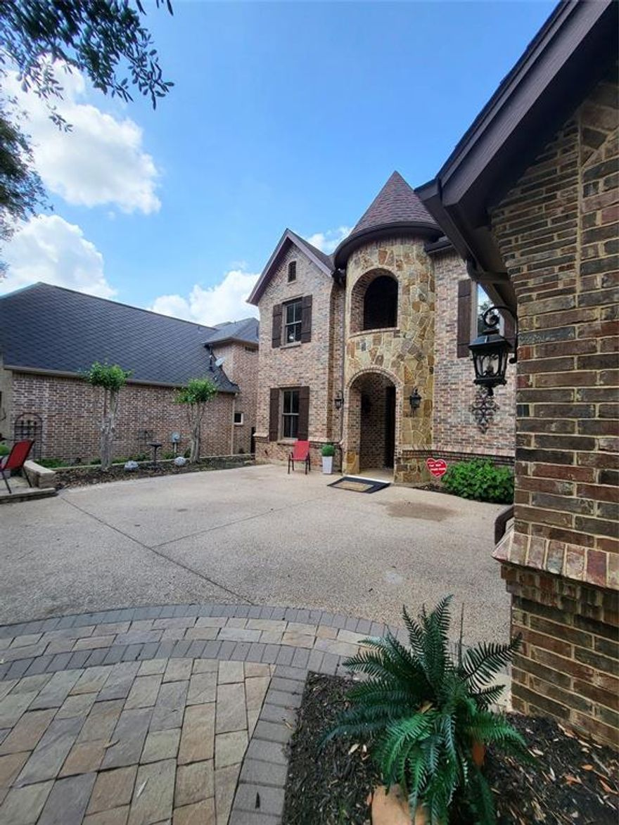 This fabulous 4.2.5.2 nestled in a quiet tree-studded gated community within walking distance of the Lake, offers true custom features found in much more expensive homes.Upon entering this French retreat,you are greeted by a spectacular wrought-iron and wood circular staircase accented with beautiful wood floors,new carpet and paint throughout.A new Class 3 roof has already been contracted.The simple elegance of the adjacent formal dining room is beautiful and understated.Soaring ceilings, an over-looking balcony, with an entire wall of custom-trimmed windows make this open-concept living room the center point of activities year-round.The striking gas fireplace with custom mantle and art niche is the room's focal point.Bright windows reveal a beautiful patio and tailored low-maintenance courtyard.The beautifully appointed kitchen offers 42 cabinets and granite countertops with a large corner pantry that makes this kitchen truly a dream.No detail was left to chance,pop-up utility plugs next to the gas range,under-counter daylight windows, and lighting are all pluses. The designer Vent-a-Hood accents the kitchen beautifully.The sunny nook and breakfast bar are surrounded by floor-to-ceiling wood-trimmed windows that looks out on the Ramada.This outdoor covered second living area with  seated hearth and TV-ready fireplace is the perfect retreat or great for entertaining.The large downstairs Primary Suite has a beautiful view of the courtyard,elegant appointed bath with a counter-height vanity with dual sinks and an over-sized Jacuzzi tub. enjoy the giant custom seated tile shower that is handicap accessible.The ensuite dressing room and closet offer his and her custom dressers and linen chest, winter and summer racks, and open shelving.The adjoining laundry area with 42 cabinets and desk makes chores a snap. 3 large split beds up and a beautiful media room are perfect.End your day enjoying your own Sunset Patio with a glass of wine and great company.