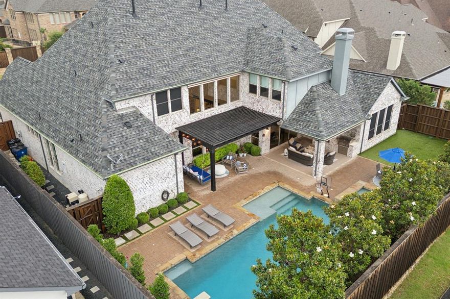 Luxurious home in gated Shaddock Estates, an exclusive West Frisco community. Shaddock Estates is situated by Cottonwood Creek Park that includes acres of lakes, trails, pavilions, and a fully stocked fishing pond. This home is an ideal layout for comfort & entertainment. The light & bright open floor plan is complemented by hardwoods, soaring ceilings in living spaces, & designer touches throughout.  Enjoy cooking in the open chef's kitchen with quartz countertops, 48 inch Wolf range, spacious island, built-in Miele espresso machine and large pantry. The primary suite features a stunning custom closet, marble bathroom, and access to the laundry room. This home is an entertainer's dream with a media room located downstairs next to the newly renovated bar perfect for hosting guests. Upstairs features 3 ensuite bedrooms, & large game room. The outdoor area features a large covered patio with remote drop down shades, turfed yard, dog run, and beautiful pool.