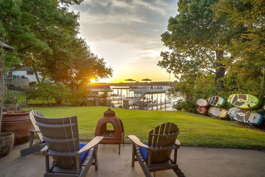 Eagle Mountain Lakefront Living! Tucked along the water's edge in Little Carter Slough, this beautifully designed 2-story retreat offers the perfect mix of upscale comfort and effortless lake life. With 5 spacious bedrooms, 3.5 bathrooms, and new built-in bunks, there's plenty of room for family and guests to relax and recharge. The upper level (street level) features a freshly painted kitchen and utility room, an inviting great room with breathtaking views of the lake, a floor to ceiling stone fireplace, a wet bar, a dedicated dining area, 4 bedrooms and 2.5 baths. The oversized primary suite boasts sweeping lake views and an ensuite bathroom with dual vanities that’s perfect for unwinding after a day on the water. The updated lower level (walkout lake level) is a private oasis with a secondary living area with built-in bunks, a bedroom featuring floor to ceiling windows with views of garden and lake, and a full bathroom with geode inspired sinks and rain head shower. Step outside into your own private backyard oasis, where lake life truly shines. Screened in porches on both levels, a spiral staircase, wraparound balcony, and pergola overlook the sprawling park-like yard that slopes to the lake. A multi-level boat dock offers the ultimate setup for boating, including automatic boat lift, and plenty of room for fishing or lakeside lounging while enjoying a beautiful sunset. Circle driveway and side driveway leading to garage provides plenty of off-the-street parking. Oversized 2 car garage with plenty of room for storage or gym equipment, and has a sink area, making cookouts a breeze.  Whether you're seeking a weekend escape or a full-time lakefront lifestyle, this home delivers comfort, charm, and incredible sunset views—all just steps from the shore. Conveniently located less than 15 miles to downtown Fort Worth, and just over 30 miles to DFW airport!