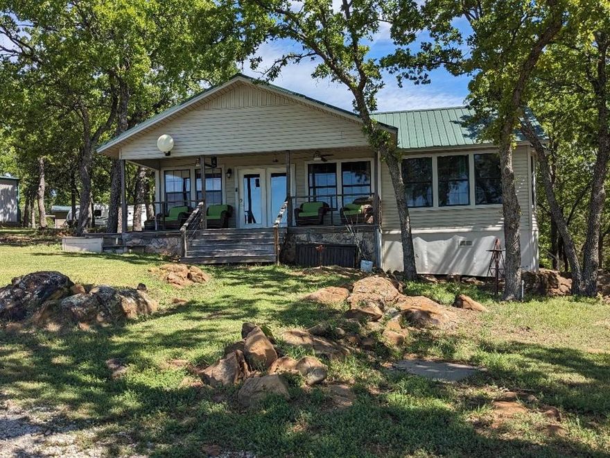 Your lovely lakefront home is just an easy hour drive outside Fort Worth city limits!  This slice of paradise will take your breath away.  There's room to bring the family for a reunion or create an AirBnB for additional income.  The main house features a front porch with panoramic views of the entire property and the side porch is covered with a door from the master bedroom and dining area for extra outside living space to enjoy your morning coffee with a view of the lake and beautiful trees.   The separate guest house is listed as bedroom 4 and 5 with 3rd bath, adding approx 650 sf to the main house (approx 2023 sf) for the total.  There's plenty of parking with 2 large garages, space for workshop and extra storage as a bonus.  You have a private swimming beach and boat launch, along with a covered dock featuring a boat lift and jet ski parking.  Finish out the evening around the firepit making hotdogs and s'mores.  The fishing is excellent and Twisted Oaks Golf Course is only .5 mi.