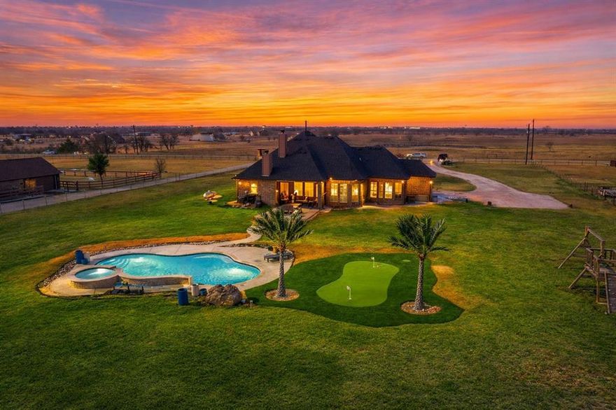 Custom-built and perfectly positioned on 2.5 acres,this exceptional property offers peaceful country living with no city taxes and no HOA.NEW pool with Spa and elegant water feature,custom putting green making this your personal retreat to sit back and relax.Inside,the open-concept floor plan is filled with upgrades and thoughtful design.The living room centers around a stunning stone fireplace,creating a warm and inviting statement space. The chef’s kitchen features a large island with drop-in sink,granite countertops,bay windows,and seamless flow for everyday living and entertaining. Plantation shutters throughout add timeless style and elagance.The private primary suite is tucked away behind the kitchen and showcases a luxurious walk-through shower with rain head,walk in closet,large soaking tub with split vanities,creating a true retreat.A dedicated office sits at the front of the home,ideal for working from home,while the split bedroom design places three additional bedrooms on the opposite side of the home for added privacy and secondary bathroom tub shower combo and double sinks Large laundry room with  additional space for folding, half bath and built in mudroom storage.Step outside and discover your own backyard oasis.A newly added pool with spa and water feature,complemented by extended concrete walkways, makes summer days unforgettable.The yard also features a custom putting green accented by two lifelike metal palm trees for a fun, resort-style touch. The east-facing backyard provides afternoon shade,perfect for Texas summers.An extended covered back patio with fireplace and flat-screen TV wiring sets the stage for effortless entertaining or relaxing evenings.Additional highlights include gated entry for privacy,an oversized garage,and an extra fenced area ideal for a dog run or keeping chickens safe.This one-of-a-kind property truly must be seen to be fully appreciated the Luxury,freedom,and functionality come together,this is country living done right.