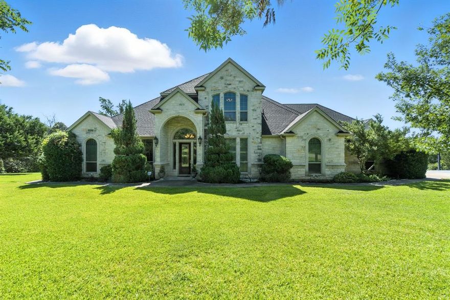 Nestled in the desirable Comanche Crossing, a gated community,  between all the conveniences Weatherford offers and highly sought after Brock ISD, this custom-built stone and brick estate blends classic charm with functional living. Set on 4.7 acres with lush St. Augustine grass and show-stopping Chinese Pistachio trees that blaze with fiery color each fall, the property is a true retreat. There is a full size sports court, and room to build out your dreams. Whether you are looking for space for your kids to roam, would like to build your dream shop, or have a few horses  - this place is the perfect fit.  Inside, enjoy three distinct living spaces: a formal living area with custom built-ins, a warm and inviting den with fireplace, and a spacious upstairs game room (pool table included) with east-facing balcony—ideal for catching peaceful morning sunrises. The spacious layout features a private primary suite and guest suite downstairs, plus two oversized bedrooms upstairs with a shared Jack-and-Jill bath.

Updates include:
New roof 2024,
Whole-house plumbing 2021,
Updated HVAC systems 1-2 years old,
 New water heater 2021,
Reverse osmosis filtration system, 
 Generac generator for winter storm outages.
Water is supplied by a Trinity Water Well.

The oversized laundry room is outfitted with a separate shower—perfect for those sweaty jobs—and a massive walk-in storage closet ready for hunting gear, Christmas décor, or anything else your hobbies demand.
With room for up to 4 horses, space to breathe, and a blend of comfort and craftsmanship that’s hard to find, this is Texas living at its finest.