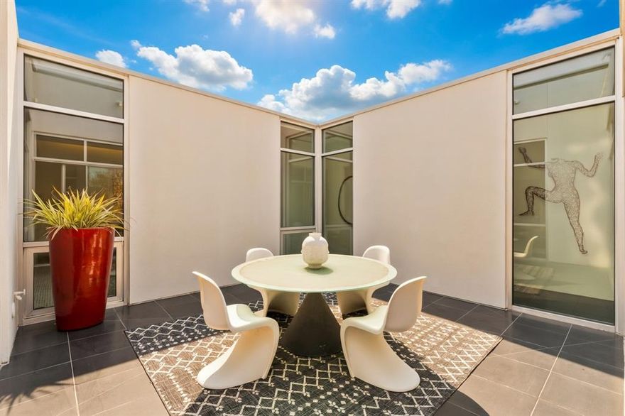 This exquisite top-floor residence at Art House is the pinnacle of sophisticated urban living in Dallas. Masterfully designed by renowned, award-winning architect Lionel Morrison, this single-level sanctuary is thoughtfully centered around a dramatic open-air courtyard that floods the home with natural light and serene greenery. The arrival is nothing short of unforgettable: a striking two-story catwalk leads to your private entry, creating an immediate sense of seclusion as you ascend among the treetops. 

Inside, the home exudes refined elegance with honed granite floors, a bespoke custom marble entry, gallery-caliber art lighting, and soaring 10-foot museum-finished walls—an impeccable canvas for showcasing prized collections. A versatile bonus sitting room offers endless possibilities: envision it as a serene library, an intimate media lounge, or a quiet retreat. The kitchen is a masterpiece of modern design, featuring sleek custom flat-panel cabinetry, expansive marble countertops, and a captivating waterfall-edge island that anchors the space with timeless sophistication. Floor-to-ceiling windows frame breathtaking treetop vistas, seamlessly blending the kitchen with the adjacent dining and living areas for effortless flow and entertaining. The expansive primary suite is a sanctuary, complete with a peaceful sitting area overlooking the courtyard, two oversized walk-in closets, and a spa-like bath crafted for ultimate relaxation. 

Nestled within Art House—an intimate enclave of just eight meticulously crafted residences—this rare top-floor gem delivers unparalleled privacy and prestige. Residents enjoy exclusive amenities—a private fitness center, two reserved parking spaces, a generous storage unit, and a state-of-the-art security and alarm system recently upgraded throughout the building. Perfectly positioned for those who appreciate architectural excellence and refined Dallas living, this exceptional home is ready to welcome its next discerning owner.