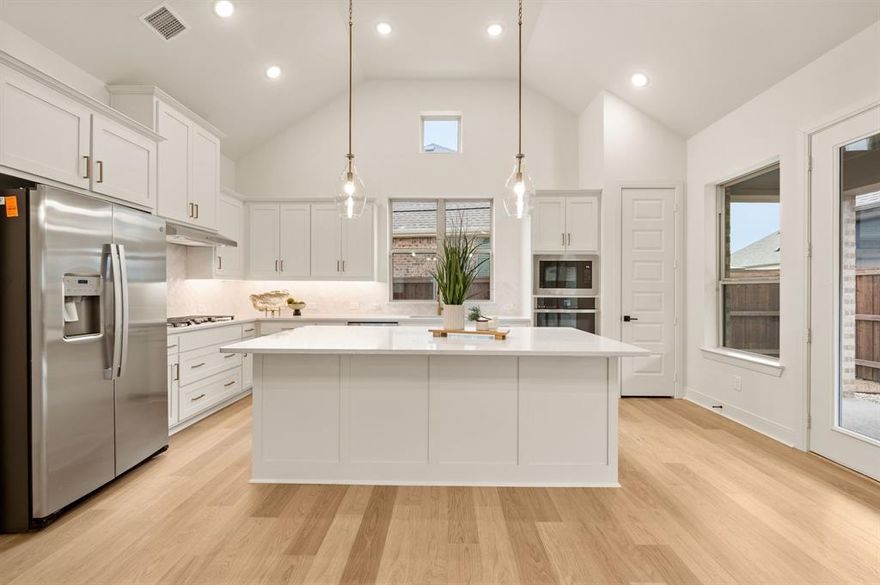 Step into this beautiful, barely lived-in 3-bedroom, 2-bath home located in a highly sought-after 55+ community with incredible amenities. Perfectly positioned across from a charming park, you can walk right out your front door to enjoy gathering with friends and neighbors. Designed for effortless entertaining, this home features a stunning open-concept layout filled with natural light and highlighted by soaring ceilings. The spacious Great Room seamlessly connects the Family Room, Dining Room, and Kitchen, creating an inviting atmosphere ideal for hosting or relaxing in comfort. A striking fireplace anchors the living area, while large picture windows and upgraded sliding patio doors lead to an expansive covered patio — perfect for a Texas-sized BBQ. The heart of the home is the gorgeous white kitchen, thoughtfully designed with white cabinetry, beautiful quartz countertops, and a large center island that offers both style and function. A window over the sink fills the space with light, and the abundant counter space makes meal prep and entertaining a dream. The clean, bright finishes perfectly complement the home’s modern, airy feel. The private Owner’s Retreat offers a spacious walk-in closet and a beautifully upgraded bathroom with designer tile. An enclosed study provides flexibility for a home office, third bedroom, or hobby room, while a guest bedroom and bath are tucked away for privacy. You’ll also love the impressive storage, including a large walk-in linen closet and mudroom area. This move-in-ready home offers style, space, and community — an ideal opportunity for anyone looking to enjoy the best of 55+ living. Enjoy the low maintenance backyard and morning coffee on your private covered patio. Seller offering $5,000 for rate buy-down. MUST SEE!