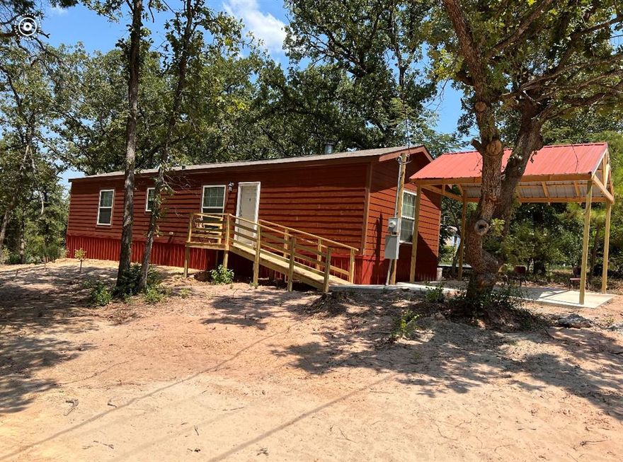 COZY CABIN GETAWAY with a BUYER BONUS of $9000. Knock a point off the interest rate, use it for closing costs, or furnish your new home! It's all up to you.  Purchased as a second home, this house, built in 2016, LOOKS NEW & is MOVE IN READY with a NEW HVAC & WOOD BURNING FIREPLACE! Includes the REFRIGERATOR, WASHER & DRYER, in addition to the dishwasher & vent hood covered stove.  Open concept floor plan utilizes every square inch & also offers a split bedroom feature. Primary bedroom includes an ensuite bathroom with dual sinks & a walk in shower. 2nd bedroom is next to the other full bath that has a shower & bath combo. A completely covered HARDIE BOARD EXTERIOR, NEW METAL SKIRTING, & a COMPLETED RETROFIT provides an extra level of stability. METAL CARPORT covers NEW CONCRETE DRIVEWAY with sidewalk leading to the DECK with a ramp. Located only minutes from shopping, schools & medical, yet maintains that country feel!