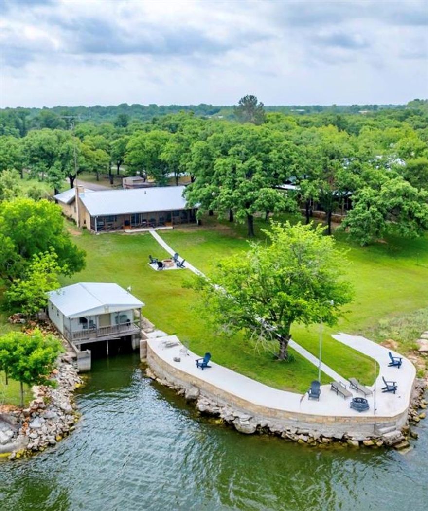 IF YOU KNOW SOMEONE LOOKING FOR A HOME ON GREAT WATER AT LAKE LEON—THIS IS IT. This beautifully maintained 2-bedroom, 2-bath brick home sits on one of the most sought-after waterfront locations on the lake, offering consistently deep water that doesn’t fluctuate like other areas.
The home features a clean, inviting interior with an open-concept living, dining, and kitchen area designed for comfort and easy entertaining. A full-length screened-in porch spans the lakeside, creating the perfect space to relax and enjoy the peaceful water views. Recent updates include a new metal roof and gutters installed in December 2025 on both the home and the crappie house, along with a recently completed retaining wall that adds both function and visual appeal. Outdoor amenities make this property truly special, including a crappie house, the ability to pump water directly from the lake, and an unbeatable setting for year-round lake enjoyment. Opportunities like this on Lake Leon are rare—especially with this combination of location, water depth, and improvements.