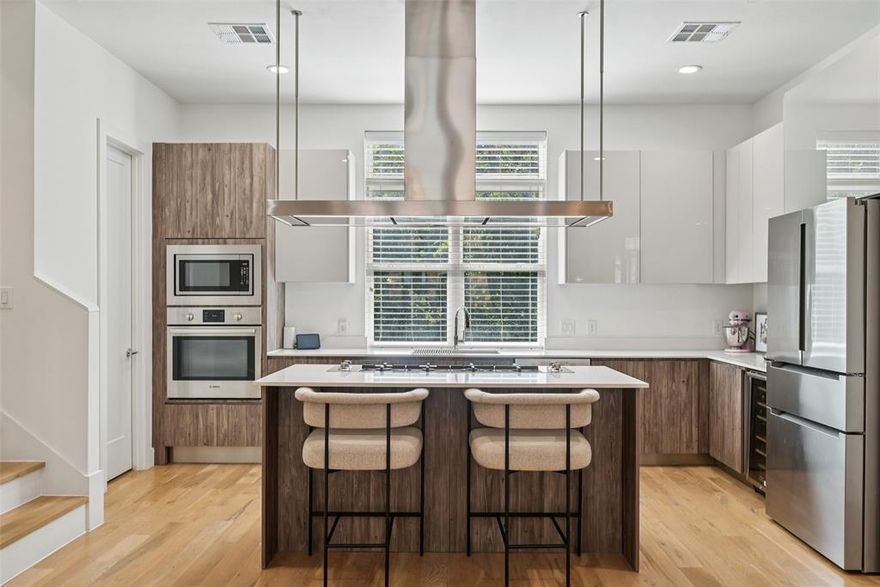 From the moment you walk in, you feel the space — and you know this one is different.

Massive kitchen island. Built-in wine fridge. Rooftop deck with Downtown skyline views. Hardwood floors throughout.

The main living level is bright, open, and wider than any townhome you've toured. Oversized sectional, real dining table, room to host a crowd — and it still doesn't feel full. This is the layout other townhomes wish they had. The kitchen matches the scale: gas cooktop, farm sink, walk-in pantry, and an island big enough to gather around.

Upstairs, the primary suite has wood floors, a real walk-in closet, and a bath with double vanity, soaking tub, and frameless marble shower. The kind of bathroom that makes you not want to leave. Second en suite bedroom on the same floor. Washer and dryer up here too — no hauling laundry between floors.

On the ground level, a full en suite bedroom opens straight to a private fenced yard through a sliding glass door. Gym, office, guest suite — or all three at different times of the week. Two-car attached garage right next to it.

And then the rooftop deck. Open sky, Dallas skyline, golden hour every night you want it. This is your new favorite room.

Ideally located in Dallas — minutes from Highland Park, Uptown, Downtown, Oak Lawn, and the Medical District.