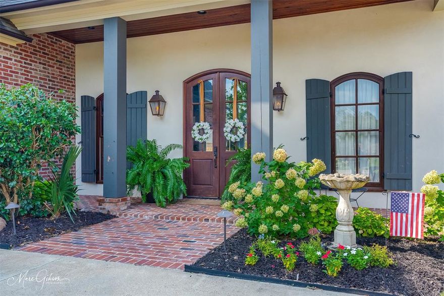 Step inside this stunning Twelve Oaks home to find an open-concept floor plan featuring exposed wooden beams, rich hardwood flooring, and abundant natural light pouring through large windows that overlook the spacious back porch. Retreat outdoors to the covered patio with arched brick details, wood-paneled ceiling, and dual ceiling fans, offering year-round comfort. The backyard is fully fenced, providing privacy and plenty of space for play, pets, or future landscaping. The gourmet kitchen boasts sleek granite countertops, custom cabinetry, stainless steel appliances, and a large island perfect for entertaining. Just steps away, the living area offers a cozy fireplace with a brick surround, creating a warm and inviting atmosphere. Enjoy the convenience of a butler’s pantry and wet bar, complete with rustic cabinetry, wine storage, and a prep sink — perfect for hosting gatherings.