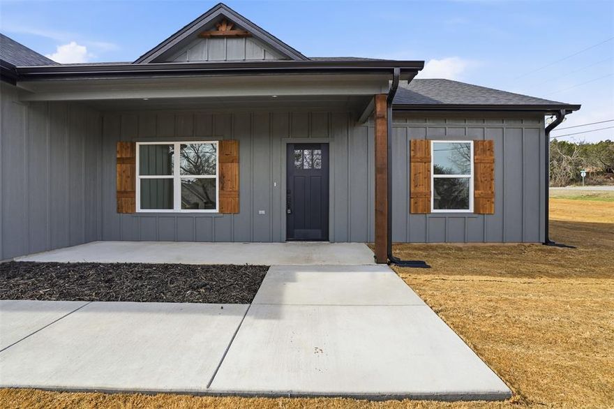 This new construction home in the heart of Granbury, TX, located in Indian Harbor community with full access to all the amenities including the marina and pool. where comfort meet classic charm in an inviting 3-bedroom, 2-bathroom residence. Perfectly sitting on a corner lot, this property boasts a double-car garage, offering convenience and style in a tranquil setting. Step inside to experience the elegant open floor plan adorned with luxurious vinyl plank flooring, seamlessly marrying contemporary design with cozy living. The spacious living area flows graciously into the kitchen, creating a perfect environment for entertaining and daily living. The kitchen is a culinary delight, featuring granite countertops, an abundance of cabinets, a versatile kitchen island. The primary suite is a quiet retreat, complete with a giant walk-in closet and an ensuite bath offering a separate shower, duals sinks and even a make up area. The split bedroom design ensures privacy, with two additional bedrooms providing ample space for guests or home office needs. Unique architectural highlights include the striking dark siding, complemented by charming cedar shutters, making this home a standout in the neighborhood. Practically designed, this residence includes a functional mudroom and a full-sized laundry room, enhancing the home's convenience factor. This haven offers modern living in a thoughtfully designed space—it’s the perfect blend of style, functionality, and nature’s beauty. Embrace a lifestyle of comfort and sophistication in this remarkable home today!