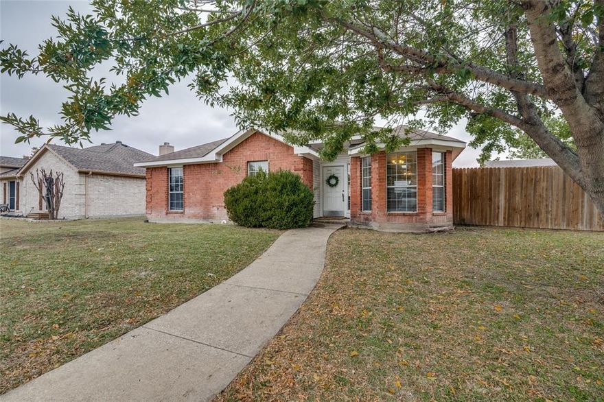 Charming single story classic red brick home featuring large picture windows and mature landscaping. The home sits on an interior residential street and showcases a traditional Texas exterior with a warm , inviting feel.