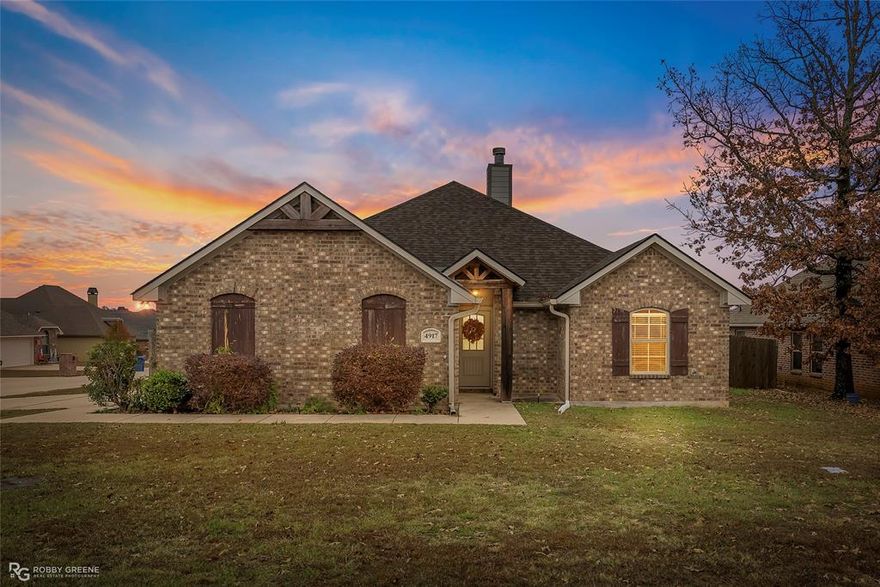 Step into this inviting 3-bedroom, 2-bath home featuring stylish ceramic wood-look tile flooring and granite countertops. The open-concept layout connects the living, dining, and kitchen areas, highlighted by crown molding, recessed lighting, neutral paint tones, and a tray ceiling in the primary bedroom. A cozy wood-burning fireplace framed by custom built-ins creates a natural focal point in the living room. The spacious primary suite offers a relaxing bathroom with a garden tub and a separate walk-in shower. Outside, you will find a covered patio overlooking the fenced backyard, perfect for outdoor enjoyment, as well as a two-car garage on a corner lot. Additional perks include a security system and convenient access to I-49 and 220, making commuting and daily errands a breeze. Schedule your private viewing today and see all this home has to offer.