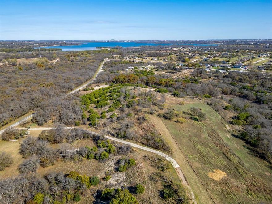 Welcome to an extraordinary opportunity in southwestern Tarrant County—a rare 11.25+or- acre property that offers one of the most breathtaking settings in the region. Ideally positioned just 20 minutes from downtown Fort Worth and mere minutes from the Chisholm Trail Parkway, this exceptional property combines exceptional convenience with truly spectacular natural beauty. Perched majestically atop one of the area's highest promontories, this prime homesite boasts absolutely stunning 270-degree panoramic views that absolutely set it apart. Gaze across a sweeping landscape, capturing mesmerizing vistas of downtown Fort Worth's glittering skyline and the serene waters of Benbrook Lake. The breathtaking views create an ever-changing masterpiece throughout the day. During the 4th of July, countless fireworks shows across Tarrant, Johnson, and Parker Counties can be seen. This canvas provides exceptional privacy and the perfect spot for your dream home. Whether you're envisioning a sprawling custom residence, an elegant entertainer's estate, or a serene retreat, this hilltop location ensures your home will be positioned to showcase those magnificent vistas from every vantage point. Design your perfect residence with the views as your constant companion. This is truly a once-in-a-lifetime opportunity to build on one of the region's most visually spectacular properties.