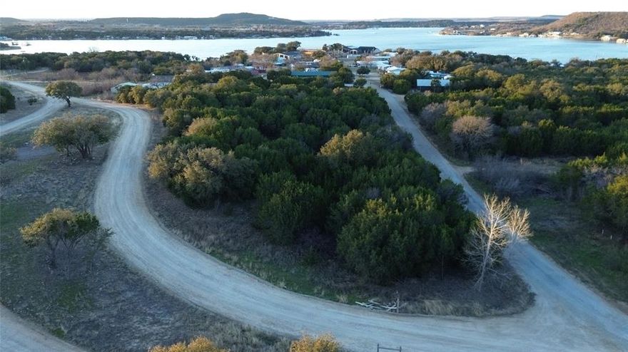 Newly re-platted lot 402-A is 2.239 acres of raw land just past the BRA public boat ramp on the west side of beautiful Possum Kingdom Lake.  Hurry to get your spot near the lake while the opportunity exists and you can be launching your boat or jet skis on the Great Lake of Texas by summer time!  Nearby lots in surrounding HOA communities are selling for much more per acre, but you can own this unrestricted lot at a reasonable price and enjoy it without extra association dues and rules.  Seller believes utilities are available, but buyer will need to verify availability of water meter and electric service; tree & brush clearing will be needed in order to build (seller has bids).  The west side of Possum Kingdom, historically more of a camps and cabins area, has recently experienced new growth - new mercantile and convenience store, updated restaurants and entertainment venues, gorgeous homes - but, it still has that laid back lake life feel that brings a sigh of relaxation when you arrive.  You know you want to be here!