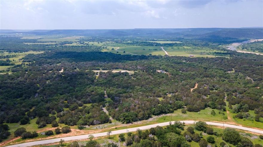 Large 5+ acre lot boasting stunning vistas nestled within the scenic River Canyon Ranch community. Enjoy the neighborhood access point to the Brazos River and benefit from an agricultural exemption upheld by the neighborhood's cattle grazing association. Electricity lines run along the road and high-speed internet is available. Anticipate the development of a 5-acre Riverfront Community Park, enriching the leisure options within the neighborhood. Embrace the opportunity to construct your dream retreat or a charming Barndominium, ideal for weekend getaways or permanent residence. Traditional home constructions are also welcomed, mobile homes are restricted per community guidelines. Revel in the tranquility of this serene environment, offering expansive views of mountains and skies, underscored by the absence of an HOA. Experience the peaceful ambiance while being just 32 miles away from a state park offering an array of recreational activities.