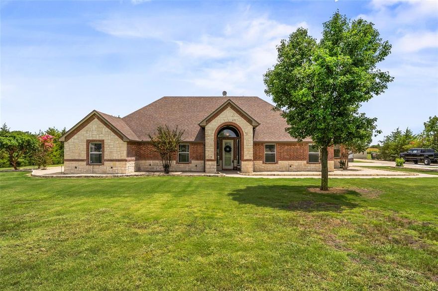 Get out of the hustle and bustle of city life and experience spacious country living at 6713 Mustang Trail. Situated on a private 2-acre lot in the highly desirable North Fork Estates of Krum ISD. This single-story brick ranch style house features 2,633 square feet of living space, including three bedrooms and two bathrooms, with a layout that incorporates both traditional and updated elements.
The heart of the home is the open-concept living area, featuring high ceilings, crown molding and a wood-burning fireplace. The adjacent kitchen boasts granite countertops, a full suite of appliances and a generous walk-in pantry. A bright breakfast nook overlooks the lush, expansive backyard, making morning gatherings effortless.
Retreat to the spacious primary suite, complete with two large walk-in closets, a jetted soaking tub, separate shower, dual vanities, and a convenient closet-to-utility room pass-through. Two additional bedrooms and a second full bath on the opposite side provide ample space for family and guests.
Recent system and finish updates ensure move-in readiness: new carpet throughout, a high-efficiency 18 SEER air-conditioning unit installed in 2023, and a water heater replaced in 2022.
Parking and storage requirements are addressed with a three-car attached garage. The third bay, equipped with durable rubber flooring, a dedicated window-mount AC unit, and pull-through garage doors, offers flexibility to serve as a workout area, office, or climate-controlled storage space. Additionally, a detached 30' × 50' metal workshop with electric provides an excellent facility for RV storage, workshop use, or supplementary equipment storage.
Outdoor amenities include an open patio, mature trees, and expansive lawn space—perfect for country living and outdoor entertaining. Don’t miss this to join one of Sanger’s most sought-after neighborhoods.