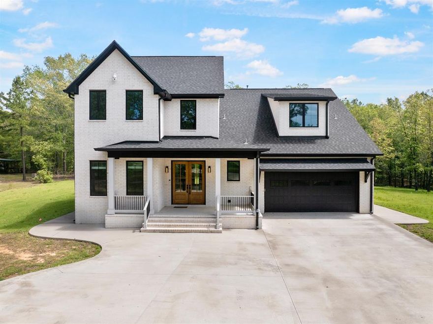 Tucked away on over two wooded acres, this stunning two-story home offers a refined blend of modern luxury and peaceful privacy. Designed with timeless appeal, the exterior showcases elegant Winterhaven White General Shale brick, setting the tone for the craftsmanship found throughout. Inside, expansive Marvin casement windows and doors invite natural light into every corner, creating a bright, welcoming atmosphere. A grand foyer opens seamlessly into thoughtfully designed living spaces that include a private study, formal dining area, and an open-concept kitchen and living room—perfect for both everyday living and entertaining. The chef-inspired kitchen features ZLINE appliances and a striking granite and quartz island, providing both beauty and functionality. The main-level primary suite serves as a true retreat, offering spa-like amenities including a jetted tub, double shower, and generous storage. Upstairs, additional bedrooms and baths are complemented by a versatile bonus room ideal for a media space, playroom, or guest retreat. Elegant finishes continue throughout with Maori granite countertops and custom glass shower enclosures. Surrounded by nature and thoughtfully designed for comfort and style, this exceptional home delivers privacy, quality, and luxury in a setting that feels both refined and serene. Schedule your private showing and experience it for yourself.
