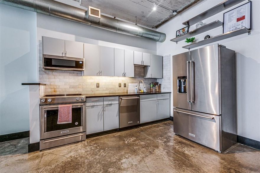 Discover a unique blend of history and modern living in downtown Dallas with this exceptional loft, located only a block away from the AT&T Discovery District. Formerly the WFAA broadcasting station and Santa Fe Terminal, located minutes from Neiman Marcus, Farmers Market, and various bars and restaurants, this historic building offers amenities like a rooftop pool, fitness center, yoga studio, concierge service, gated parking, concrete floors, exposed brick, and same-level storage.
This stunning 9th-floor loft unit features high ceilings and an open layout, seamlessly integrating modern updates with vintage character.
The unit features a newly-renovated bathroom, including a spacious walk-in shower with stone floor and a contemporary vanity, large windows, Nest thermostat, remote control custom shades and custom lighting. The kitchen has stainless steel appliances, new modern cabinets, granite countertops and a modern stone backsplash. All kitchen appliances to stay including refrigerator and washer dryer.  An assigned garage parking space and  a 5x5 storage unit across the hallway are  included.  A 9x8 nook upon entry has plenty of room to double as laundry room and home office combined.  HOA fees cover water, trash, concierge, on-site and internet. Any other furnishings are negotiable with offer.