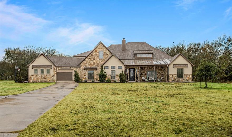 Set on a beautifully wooded lot, this exceptional custom home offers timeless craftsmanship, thoughtful design, and a true sense of retreat.  From the moment you arrive, the stone exterior and welcoming front porch set the tone for the character and quality found throughout.
Inside, you’ll find designer tile selections, striking interior stonework, and custom cabinetry and built-ins throughout.  Exposed beams, arched stone accents, and curated finishes greet you as you walk in the front door and provide a seamless flow ideal for both everyday living and entertaining.  The spacious kitchen features custom cabinets, abundant storage, and a large island that anchors the home—perfect for gatherings large and small.
The primary suite is a dream come true with perfect views of the wooded lot and a spa-like bath with room to unwind.  The large walk-in closet adds both luxury and functionality.  Additional bedrooms are generously sized, and the two additional living spaces offer endless opportunities to spread out while hosting or relaxing.  Above the garage, the upstairs bonus room offers flexibility to craft your dream space.
Step outside to your private backyard oasis complete with a stunning pool, fireplace, extended patio and more, all surrounded by mature trees that provide both privacy and beauty.  Multiple electrical outlets placed throughout the trees allow for effortless holiday or ambient lighting year-round. Additional highlights include a storm shelter for peace of mind and an extra garage offering ample storage and versatility.
This one-of-a-kind property blends luxury, comfort, and nature into a home designed to be both lived in and loved.  You don't want to miss it.