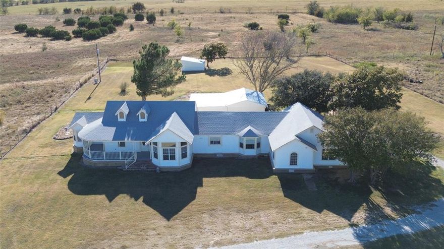 Stunning Bosque County Country Retreat on 2.75 Acres in Clifton ISD, just outside of town!
*PLEASE NOTE: Tax records show this home being built in 1945. The right side is the original home built in 1945 and is now the additional living area, which has all been updated. The main house was completed in 2021 and not lived in until then. The home is virtually brand new!
Welcome to your dream home nestled in a sought-after area just outside of Clifton, beautifully designed with 3,613 SF, 5 bed, 3.5 baths, additional private living area, great for multi-generational living or hosting guests. Situated on a low maintenance secluded lot without solar panel views, this property offers privacy, serenity, and endless possibilities. Inside be welcomed by timeless craftsmanship, walk in closets, expertly crafted crown molding, wainscoting, custom windows, marble finishings, herringbone flooring, recessed & custom lighting in and out, brand new carpet in all bedrooms adds comfort. The kitchen is ready to serve, complete with all appliances included, open floor plan flows easily into multiple living spaces—ideal for both entertaining and everyday living with plenty of room to stretch out! Peace of mind with brand new septic, 2 brand new water heaters  and 2 HVAC units-one just a year old, a security system only 2 years old. Outside experience true Texas charm with a wrap-around covered porch, perfect for enjoying sunrises, sunsets and peaceful country views. The property is fully fenced with a private electric gate and features a 6-car carport with electricity, an enclosed barn-workshop with power, and an air-conditioned outbuilding ideal for a home office, she shed, playroom or creative studio plus 2 additional shipping containers for storage. This one of a kind property combines luxury, function, and flexibility for guests or multi-generational living—offering a peaceful country lifestyle just minutes from all the conveniences of Clifton.