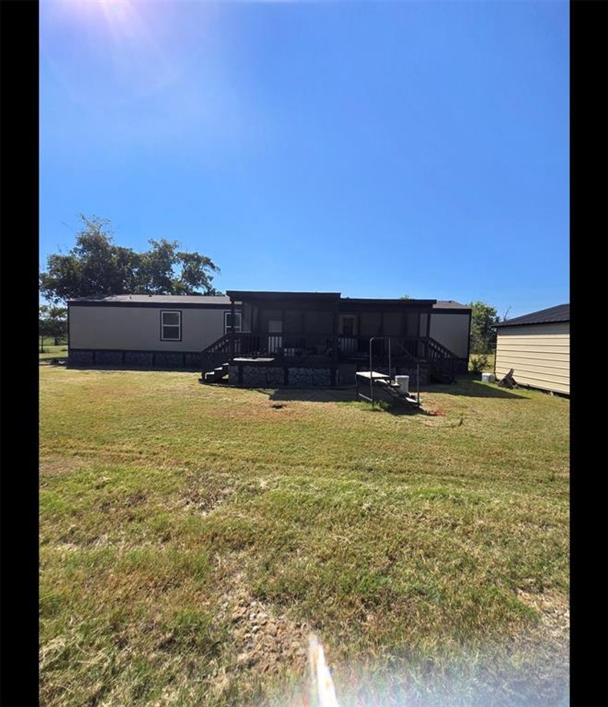 Welcome home to this charming country-style living. This single-wide mobile home, along with the surrounding land, is ready for its new owners. If you’re seeking a place to call home with ample outdoor space, you’ve found it! Enjoy the benefit of no city taxes, a fenced-in acre, and a wrap-around gravel driveway. The property also features a two-car carport and a 12x28x6-foot shed with electricity. Both the front and back decks are covered, highlighting the thoughtful planning that has gone into this home. The Craftsman lawnmower will be conveniently stored in the shed for you, and the TVs will be left mounted on the walls throughout the entire house.