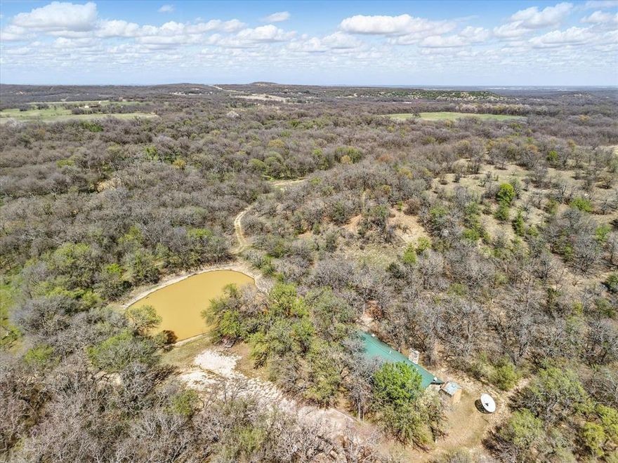 Motivated Seller.  Priced to SELL. Phenomenal Agricultural Exempt Legacy Wild Game Hunting Ranch with Small Lodge, that's ready for your customization and updates. This land has loads of Deer, Hogs, Turkey, Birds and more. Natural and manmade ponds are in many places throughout the property.  You get to keep all the deer blinds and feeders too.  Cattle rancher is willing to continue the grazing lease in order to assist new owner with agriculture exemption as well. You'll find outstanding elevation changes, from a creek with FEMA floodplain to high rocky ridge tops.  The area around the private and fully equipped lodge is on higher elevation and has a private water well, septic, electricity, indoor fully ventilated smoker for your brisket and game, indoor stainless steel prep area, cold AC, fully functioning heating and so much more.  We personally photographed many groups of hogs, deer, and ducks on the ponds, and signs of wildlife throughout the entire property.  This ranch includes lush and fertile bottom land outstanding for grazing cattle, equine activities, pasture land, coastal or a wide variety of agricultural uses.  The property includes an enclosed barn for your equipment, an open hay barn near the hayfield, the land does have a few pumpjacks and tanks, and they're all located on the southern side of the land which keeps them separated and away from your agricultural, hunting and outdoor uses.