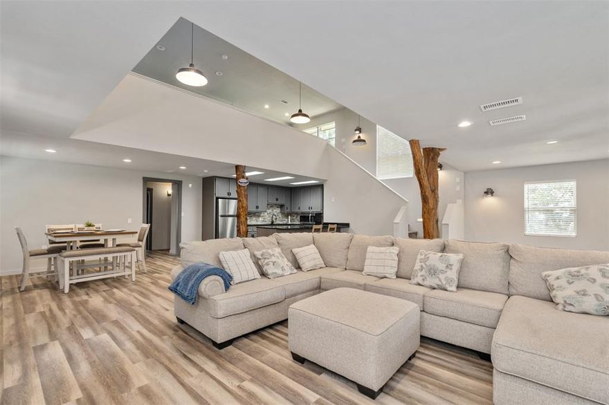 Welcome to your own lakeside retreat that offers breathtaking views of the lake! Beautifully renovated throughout on 2 lots with community boat launch. Home features a huge open floorplan with room for two Living areas and a Formal Dining. Kitchen has granite counters, beautiful brick wall and backsplash, breakfast bar, farm sink. Decorative lighting, luxury vinyl flooring and 2 inch blinds throughout. Accent woodwork for columns. Living and Formal Dining lead to a balcony. Downstairs has two additional bedroom and bath with a pedastal sink and walk in closets. Spacious laundry room has room for freezer or additional refrigerator. Upstairs has a gameroom area, and huge master ensuite with a private bath and granite vanity. Additional bedroom upstairs has walk in closet and open concept with room for multiple beds or a bunkhouse theme. The is also an upstairs balcony. This is a great house for entertaining large families and friends. The exterior is easy maintenance vinyl siding. Additional parking for boat and guests. Positioned across the street from the lake, fabulous trees and access to a community pier and boat launch. Outdoors has a charming fire pit area, complete with chairs for your relaxing lakeside living.