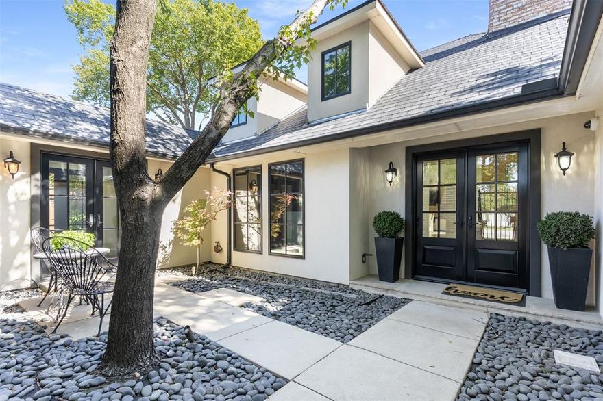 Nestled beneath a canopy of mature trees this one-story gem exudes the kind of calm you only find when you leave the everyday hustle and step into a place that just welcomes you home. Inside, the heart of the house opens with wide plank hardwood floors stretching through a generous living area where walls of glass frame the lush backyard like a live painting. Cozy fireplaces anchor both sides and sunlight dances across every living space. In the adjoining eat-in kitchen, enjoy all natural stone counters and backsplash, custom cabintry, and Thermador appliances all hinting at a chef’s flair without losing any of the everyday comfort. The master suite is a private retreat tucked away on its own side of the home where you’ll find privacy and space for a quiet morning coffee or a good book by the window. In addition to the two secondary rooms you have a home office and a separate fully finished bonus room with private access, custom cabinetry, beverage cooler, and an abundance of natural light. Step outside through French doors and you’ll find an oasis - imagine summer days splashing in the pool, evenings under the stars, the gentle hum of the city softened by the leafy lot. The oversized lot gives you privacy, room to roam, and relax—whether it’s garden boxes, outdoor entertaining, or just a spot for the dog to enjoy. Accompanied with the house is an equally finished guest quarters offering a private bedroom, full bathroom with laundry connection, and a kitchenette. Then there’s the four-car oversized garage wrapped in convenience with epoxy flooring, storage cabinets, and an attic with plenty of additional storage space. Desirably located in the highly regarded 75209 zip code, with easy access to the vibrant Park Cities and the energy of Uptown Dallas, you have both neighborhood charm and big-city convenience. This is more than a house; it’s a setting for Sunday morning pancakes, backyard barbecues, quiet fireplaces in winter—and all the moments in between.