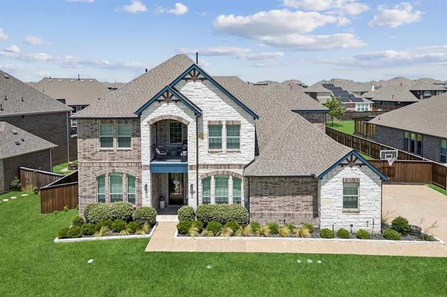 Situated on an oversized lot in the gated village of Inspiration, this beautifully upgraded 5-bedroom, 4-bath Castlerock Frisco model blends modern elegance with lakeside community charm. Enjoy peaceful greenbelt views with Corps of Engineers land directly across the street—offering lasting privacy and tranquility in one of Wylie’s most desirable communities. A stone façade, front balcony, and uplighting create a striking exterior, while a 4-car garage with epoxy flooring and Tesla charger adds utility and polish. Inside, the home is loaded with luxury and smart technology. A soaring floor-to-ceiling stone fireplace anchors the living room, where motorized blinds, smart ceiling fans, and a 7.1 in-wall surround sound system elevate comfort and entertainment. The fully remodeled kitchen boasts quartz counters, a reconfigured island with built-in storage, double ovens, a 36 inch farmhouse sink, under-cabinet lighting, touchless faucet and disposal, and a designer backsplash—ideal for culinary creativity and gatherings. Additional features include a private study, a downstairs guest suite, a central home vacuum system, an interlock switch for whole home generator, and a dramatic curved staircase leading to three more bedrooms, two baths, a spacious game room, and a media room with 5.2.1 Dolby Atmos surround sound and screen. Designer carpet and thoughtful finishes continue throughout. Outdoors, an extended 11x22 ft covered patio hosts a built-in stone wood-burning fireplace, outdoor kitchen with fridge and storage, dual gas stubs, Bluetooth surround sound, and smart lighting around the privacy fence. A custom turf dog run with doghouse adds charm and convenience. Smart home features include August Lock, Google security cameras, doorbell, smart thermostats, garage door openers, smart dishwasher, both ovens, and smart blinds in the primary suite and living areas. Residents enjoy Inspiration's resort-style amenities—pools, lazy river, gym, dog parks, and more.