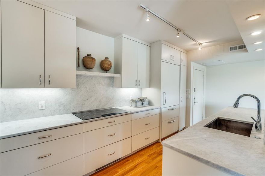 Rare opportunity on Turtle Creek Blvd! This updated 7th-floor unit in an iconic mid-century building features an open layout with generous living space, floor-to-ceiling windows, and a spacious balcony overlooking the treetops of central Dallas. The ample living room, perfect for hosting gatherings is anchored by a custom entertainment cabinet and a large niche for your cinema-size flatscreen tv. The gourmet kitchen is ideal for both everyday living and entertaining and features a large eat-in island, marble-topped custom cabinetry, and a built-in Sub-Zero refrigerator. Hardwood floors run throughout the living spaces and bedrooms, and stone floors and finishes add to the refinement of the spa-like bathrooms. Completing the tailored look are custom-fitted blinds on all the windows. The building boasts luxury amenities, including a fitness center, pool, lounge-like reception, and beautifully maintained grounds, in close proximity to Turtle Creek, the Katy Trail, and many shops and restaurants.