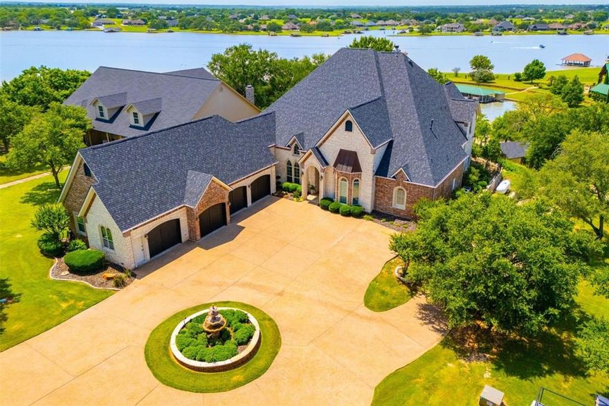 Ready to be lucky enough to call this luxurious waterfront retreat yours? This custom estate is the perfect blend of architectural grandeur plus the charm of small-town lakeside living, just 45 minutes from downtown Fort Worth. Designed as a true escape by offering built-in amenities and serenity at every turn. Be welcomed to an open-concept living framed by panoramic lake views. The show-stopping kitchen is a chef’s dream, crafted for seamless entertaining and elevated everyday living. Wake up to water views in the breathtaking primary suite, complete with a sitting area, spa-inspired bath, and dual custom closets. Upstairs, a media room, an expansive game room with a fully equipped bar, and a large balcony overlooking the sparkling infinity pool and lake beyond can be yours. This home delivers experiences most properties simply cannot. Each space is intentionally designed for both function and sophistication. Additional bedrooms provide comfort and privacy for family and guests, including a 2nd downstairs bedroom, and the upstairs layout offers the option for generational living with its own wing. Outdoors, the infinity pool appears to spill into the lake, surrounded by stone decking, mature trees, and three tiers of entertaining space, including a gazebo, private dock, and direct waterfront access. Whether boating at sunrise or enjoying quiet evenings poolside, this is Texas lake living elevated. Opportunities like this are rare in Granbury. Experience what life on the water can truly become. Recent additions include an expanded laundry room and mud room, new carpet, paint, a fridge, and more!  A MUST SEE.