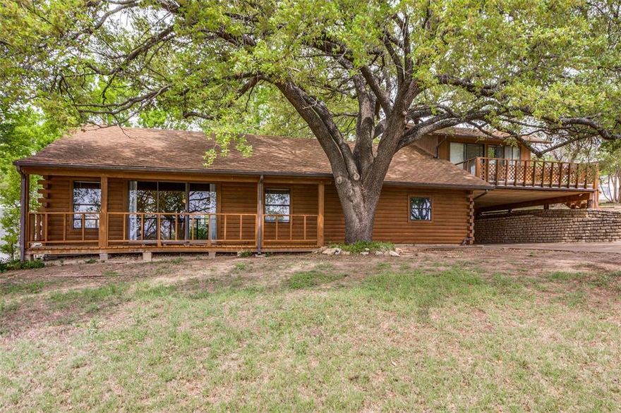 Tucked away on a rare double lot just moments from the lake in Granbury, this property offers a unique opportunity to create your own peaceful retreat surrounded by nature. With mature trees, river views from the porch, and a quiet Northside setting, the lifestyle here is hard to replicate.
Inside, the main living and dining space is filled with character, featuring vaulted ceilings, rich wood paneling, and abundant natural light. The open-concept layout and vinyl plank flooring create a comfortable, functional space with plenty of potential to make it your own.

The main home includes 3 bedrooms and 2 bathrooms, with a practical layout and laundry conveniently located in the kitchen. Upstairs, a separate room and full bath with a private entrance and window unit offers flexible use — ideal for guests or a home office! 

Located just approximately 5 miles from the Granbury Square and close to everyday conveniences like HEB, dining, and shopping, this home offers the perfect balance of privacy and accessibility.

Additional features include covered parking on both levels and a storage area with electricity in the carport, perfect for tools, hobbies, or extra storage.
Whether you’re looking for a weekend getaway, investment opportunity, or a home to update and personalize, this property stands out for its rare lot size, peaceful surroundings, and proximity to the lake.