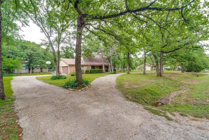 4-bedroom single family home in Burleson on 0.8712 acres offering space, privacy, and functional acreage living across from Southern Oaks Golf Course. Located in Burleson ISD, this 2,284 SF two story home built in 1976 blends updated interior features with extensive outdoor improvements, workshop space, and mature trees.

Interior features include 4 bedrooms and 2 bathrooms with a flexible layout featuring a front living or dining space, brick fireplace, and loft game room. The kitchen offers 3cm granite countertops, 42 inch cabinetry, built-in pantry, granite window sills, and a Bosch ultra-quiet dishwasher. The primary suite includes a tray ceiling, walk-in closet, and ensuite bath with dual sinks and abundant storage. Secondary bedrooms include walk-in closets, and a Jack and Jill bathroom configuration. New laminate wood flooring has been installed in the main living area, and every room includes a ceiling fan.

The home operates fully electric with a laundry mud room equipped with AC and electric hot water. Fiber internet is available through AT&T or Spectrum. Septic system is aerobic with tank replacement in 2025 and pump and aerator updated in 2026. Private water service is provided by Aqua America.

Outdoor living is a standout feature with 58 mature oak and elm trees, rose gardens, covered patio, and a private nature pond with goldfish, frogs, and toads. Wildlife is frequently seen including foxes, woodpeckers, and roadrunners. Additional improvements include a greenhouse with new roof and water access, chicken coop, tractor barn, and multiple water access points across the lot.

A large workshop provides drive-through RV and boat storage with electrical, sink, shower, toilet, and water heater, previously used as a dog wash and workspace. The insulated garage includes cabinetry, freezer space, and new springs.

Quiet, walkable neighborhood near Old Town Burleson with quick access to I-35 and approximately 15 minutes to Fort Worth. No HOA.