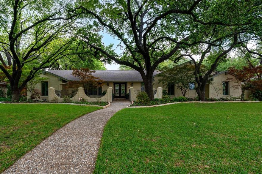 Nestled beneath a beautiful canopy of mature trees in the heart of Northwood Hills, this exceptional single-story residence offers a rare blend of refined living and effortless comfort. Thoughtfully designed with a split-bedroom layout, the home provides both privacy and flexibility for today’s lifestyle. The serene primary suite is a true retreat, featuring separate his-and-her vanity areas, dual walk-in closets, and access to a cedar-lined hall closet. A privately situated fourth bedroom with an updated bath with shower is ideal for guests or multigenerational living. At the center of the home, the chef’s kitchen is designed for gathering, complete with an expansive island that opens seamlessly to the family room. The Family Room is anchored by a custom tile fireplace and vaulted beamed ceiling, complemented by rich wood flooring, plantation shutters, and integrated surround sound—creating an elevated yet comfortable atmosphere for both everyday living and entertaining. Walls of windows and three sets of French doors create a seamless connection to the outdoors, filling the home with natural light and framing picturesque views of the backyard and pool. The outdoor living experience is equally compelling, featuring a lush grassy area and an expansive covered patio designed for al fresco dining, entertaining, and generous grilling space. Surround sound extends outdoors, enhancing the ambiance for gatherings year-round.
A true gardener’s delight, this home captures the essence of Northwood Hills living—gracious, private, and effortlessly elegant.