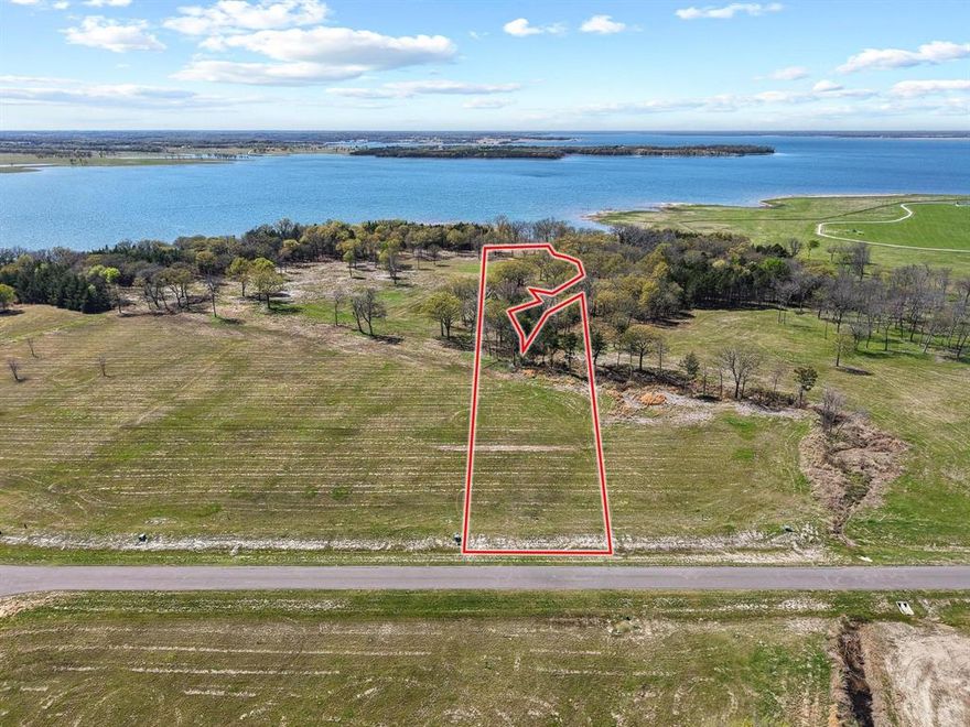 LAKEFRONT PARADISE ON BOIS D’ARC LAKE! This exceptional 3-acre lakefront lot offers several hundred feet of shoreline on the main body of deep water at beautiful Bois D’Arc Lake in Honey Grove, TX — and you can bring your own builder to create the lake retreat of your dreams! This lot has plenty of room to build your custom home with 100' across at the street, add a pool near the home, or zip lines through the trees and fire pit with covered patio to enjoy the sunset views and listen to the water. Set within a gated section of the community, this rare property features dock-capable, (pending NTMWD approval), mature trees, a spacious grassy area, and expansive water views that offer a perfect blend of natural beauty and peace. With personal docks allowed, you’ll enjoy direct access to all the lake has to offer — fishing, boating, relaxing, and breathtaking sunsets. As part of a thoughtfully planned luxury lakefront development, you’ll also enjoy exclusive amenities including a clubhouse with lakefront pool, putt-putt course, fitness center, and grilling area for entertaining. Coming soon: dog park, pickleball courts, playground, multi-sport field, community marinas. Plus, you’re just minutes from Bonham for shopping and everyday conveniences. Don’t miss this unique opportunity to build your dream home on one of the most desirable lots on Bois D’Arc Lake!