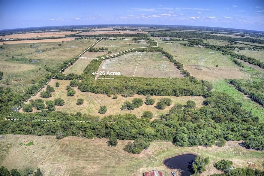 Located just north of Greenville and approximately five miles east of I-30, this ±26-acre tract offers a versatile opportunity for buyers looking to build, invest, or enjoy more space in a growing area of Hunt County.

Surrounded by established 1+ acre homesites, the property sits within an active rural residential area, making it well-suited for custom homes, barndominiums, manufactured homes, or small-scale development.

Access is provided by Rolling Lane, a paved county-maintained road, with Shady Grove water and underground electric available at the property line—helping reduce upfront costs and simplify the building process.

The land features level topography with a mix of open pasture and scattered trees, allowing flexibility in layout and use, whether for a private homesite, multiple residences, or recreational use.

Located outside city limits with no HOA, this property offers the freedom to build and use the land without many of the restrictions found in traditional neighborhoods.

With continued growth expanding from Greenville and convenient access to I-30, this tract presents a strong opportunity for both immediate use and long-term potential.