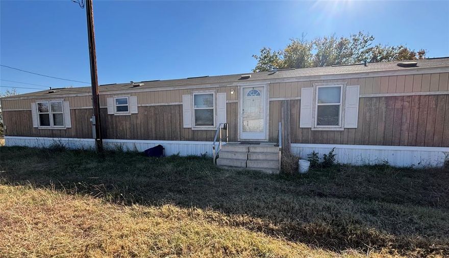 Manufactured home with parking on lot. Front faces west.