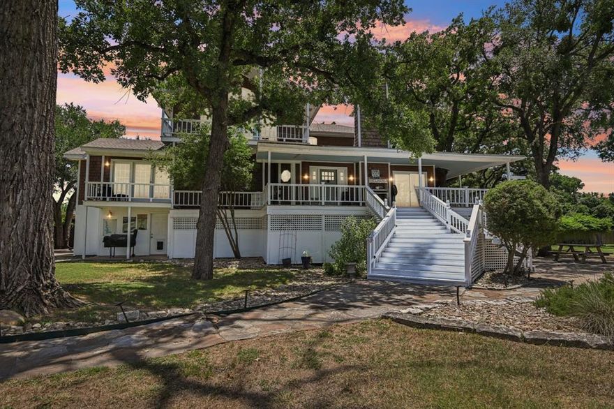 MOTIVATED SELLER!
Stunning Lakefront Estate with Guest House, Income Potential, & 2.75 percent assumable loan. 

Welcome to one of the most beautiful lakefront properties you'll find anywhere. This gorgeous 3-story home offers timeless beach house charm with cedar shaker shingles, a spacious wraparound porch, & breathtaking waterfront views.

The main level features an expansive open-concept living & kitchen area with built-in buffet, & a brand-new spa-inspired primary suite with luxurious bath. With 4 oversized bedrooms, 4.5 baths, 3 distinct living areas, 2 dining spaces, a flex room, & large walk-in closets throughout, there's room for everyone.

The ground floor offers a perfect setup for a private apartment or in-law suite, & additional storage & workspace are no problem with an attached 2-car garage (plus extra space), a shop, & a detached 3-car garage.

Bonus: a charming 1,000sf guest house with 1 bed, 1 bath adds even more value & flexibility.

The 4 + acre grounds are a dream: over 200 mature trees, tons of wildlife, a sand volleyball court, basketball area, gazebo, private dock for a fishing boat or jet skis, & serene lake views that make this property feel like a private resort. Best of all in addition to the 1.6 acres, you get an extra approx 2.5 acres of personal use land with direct access easement to Holly Island. This is land that is yours to use but you do not have to pay taxes on it! It also sits just behind Eagle Mountain Park with miles of beautiful trails, & the marina is just down the street. This home feels like you have escaped it all but it is just minutes to Saginaw, 20 min to downtown Fort Worth & 45 minutes to DFW airport. 

Currently operating as a successful short-term rental & wedding venue, Cottage Mariposa offers both lifestyle & income potential. Furniture & venue décor are negotiable—move right in or take over a turnkey business.

Don't miss this rare opportunity to own a lakeside retreat with endless possibilities!