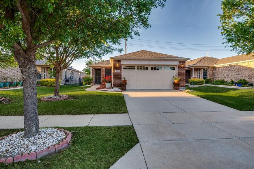 Welcome to easy living in the highly desirable Frisco Lakes by Del Webb 55+ community. This beautifully maintained single-story home offers a warm, comfortable layout with inviting spaces both inside and out. From the moment you arrive, the mature trees, manicured lawn, and charming curb appeal create a welcoming first impression. Inside, you’ll find rich wood flooring, abundant natural light, and a well-designed floorplan that blends open-concept living with flexible spaces for everyday comfort. The spacious living and dining areas flow easily together, making the home feel open yet cozy. A separate front room provides the perfect spot for a home office, reading room, or hobby space. The kitchen features granite countertops, generous cabinetry, black appliances, and a breakfast bar that opens to the main dining and living area, making it ideal for both daily living and casual entertaining. The primary suite offers a relaxing retreat with an ensuite bath that includes dual sinks, granite counters, and a large walk-in shower. Out back, enjoy a covered patio and a beautifully kept yard with room to garden, unwind, or simply enjoy a quiet morning outdoors. Frisco Lakes by Del Webb is known for its active adult lifestyle and outstanding amenities, including golf, fitness centers, indoor and outdoor pools, tennis, pickleball, walking trails, clubhouses, and a full calendar of social events and activities. This is an excellent opportunity to enjoy low-maintenance living in one of Frisco’s most sought-after 55+ communities. The community has many amenities available for use by residents. These include three fitness centers, an indoor walking track at the Village Center, three outdoor pools, a large indoor pool, eight pickleball courts, four tennis courts, and outdoor walking and biking paths. The community also has space for large community parties and dances, craft activities, cards and dominoes games, and lifelong learning classes.