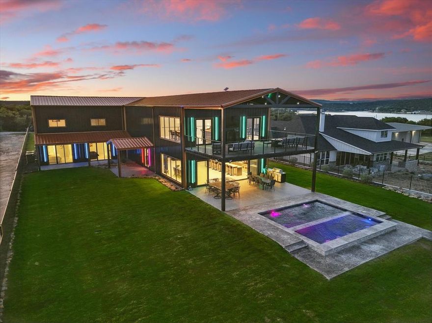 NEXT GEN-LAKE LODGE New Construction, Max Size NEW Dock, Resort-style Amenities, Sleeps 30+, STR Ready! One-of-a-kind, lake estate, offering breathtaking panoramic lake views. A rare level lakefront lot with massive natural boulder 50 ft deep shoreline, easy access to a big beautiful deep-water dock. This 6830 sq ft luxury lakefront home offers 10 bedrooms and 7.5 bathrooms, including 4 private master king suites, 5 additional king bedrooms, and an oversized 8-bed bunk room. Built for entertaining, income potential, or a personal retreat, the open-concept layout features oversized living, kitchen, and dining areas with soaring ceilings and seating for 60 plus. Still customizable to match your style, this home blends bold design with smart features. The upper-level 1000 sq ft air-conditioned game room includes pool tables and a full saloon-style bar, opening outside to an open-air observation deck with smart ambient lighting, sound system, gas firepits, and incredible panoramic open lake views. Outdoor living offers 1200+ sq ft of covered seating areas, a custom lakeside pool with in-water bar seating, and a 20-person spa with smart controls. The lush, level yard is perfect for yard games like cornhole, bocce ball, or frisbee, and leads to the easy access nature walk through boulders to the maximum sized 2000 sq ft deep water double-decker dock featuring 2 large boat lifts, PWC ports, and generous space for fishing, swimming, and relaxing. Additional features include 4000 sq ft of tile flooring, a large laundry room with 3 stackable washer & dryer sets, smart lighting, and sleeping for 26–30 guests. Fully furnished or finish to your taste. Easily hosts events of 50–75 people. Located near The Breakers Marina and top lakefront dining, all within side-by-side or paddleboat reach. A rare opportunity for young professionals seeking a modern lakefront lifestyle with flexibility and rental potential. Video NEXTGENLAKELODGE dot COM