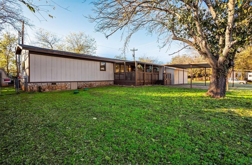 Recently updated single wide manufactured home with views of Lake Granbury from your front porch! A short 5 minute walk to the Lake from your driveway! This home also has a small add on and is located on an almost quarter acre corner lot! Welcome home to this wonderfully updated home conveniently located between Granbury and Weatherford. Built in 1980 but recently taken all the way down to the studs and completely remodeled! 1310 square feet featuring 3 full bedrooms, 2 full baths, large and open living room, very functional kitchen, breakfast area just off the kitchen, a separate utility room with washer and dryer included, and more! An incredible 21 foot wide and 15 foot long covered walk up front porch AND a large covered back porch as well. 2 car metal carport AND a 1 car enclosed detached garage! Inside you will find wood look laminate flooring, new carpet in the bedrooms, granite countertops in the kitchen that also includes full appliances. Refrigerator, cooktop stove, dishwasher, and built in microwave. Ceiling fans in all rooms and walk in closets in the bedrooms. Primary bedroom is separate from the guest bedrooms for the ultimate in privacy. Central heat and AC for the ultimate in efficiency. The outside of this home has so much to offer. Large mature trees, grass, and all located on a large corner lot. Chain link fenced back yard is perfect for the kids and pets. This home is located in the community of Arrowhead Shores. Arrowhead Shores offers Lake Granbury access with a private boat ramp, clubhouse, community pool, and community park. This home has a lot to offer its new owner with beautiful updates, ample parking, and priced to sell!