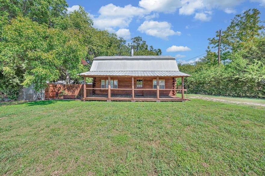 Set near a backdrop of mature trees in the heart of Lorena, this log-style home offers warmth, space, and soul. The wide front covered porch welcomes you in with room to sit awhile and enjoy the comfort of small-town life — where folks still wave hello and the pace feels just right. Inside, the living area opens up under exposed beams with rich wood detail, stained concrete floors, and a wood-burning fireplace that adds just the right kind of comfort.
The kitchen brings together rustic charm and practical updates, featuring stainless steel appliances, vintage-style cabinetry, and a passthrough bar that connects easily to the dining area. Upstairs, all three bedrooms feel tucked away and quiet, with sloped ceilings, warm wood accents, and plenty of natural light. The full bath features slate tile while the downstairs half bath adds convenience.
Out back, the large deck leads to a private yard shaded by nearby trees, with a storage shed and plenty of room to create your own peaceful space. Just minutes from the major shopping and medical hub at I-35 and Hwy 6, this home offers the ease of nearby amenities with the charm of Lorena’s slower, sweeter rhythm.