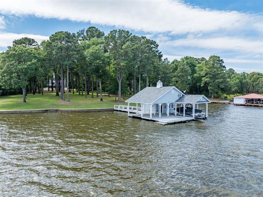6.5 waterfront acres on Lake Palestine! The owner has carefully preserved an ideal building site near the water for a large custom built home, while strategically locating and building an existing guest house for immediate use. A concrete entrance drive with electric-solar gate between brick columns turns into a natural road as it meanders through the towering trees toward the lake. Underground utilities are run from the road. The house exudes charm & modern comfort. Enter from the covered porch into an airy living, dining, & kitchen, complete with a stone fireplace w access to lakeside screened porch. Primary bedroom & bath are on the main floor, with 2 bedrooms & full bath on the second level. Concrete bulkhead spans 240' of shoreline, with a 5' concrete sidewalk cap, & wide curved stairs descending into the water. 2-Lift boathouse with Air conditioning & full kitchen. Open water views facing east across the lake. 10' of water depth at full pool.