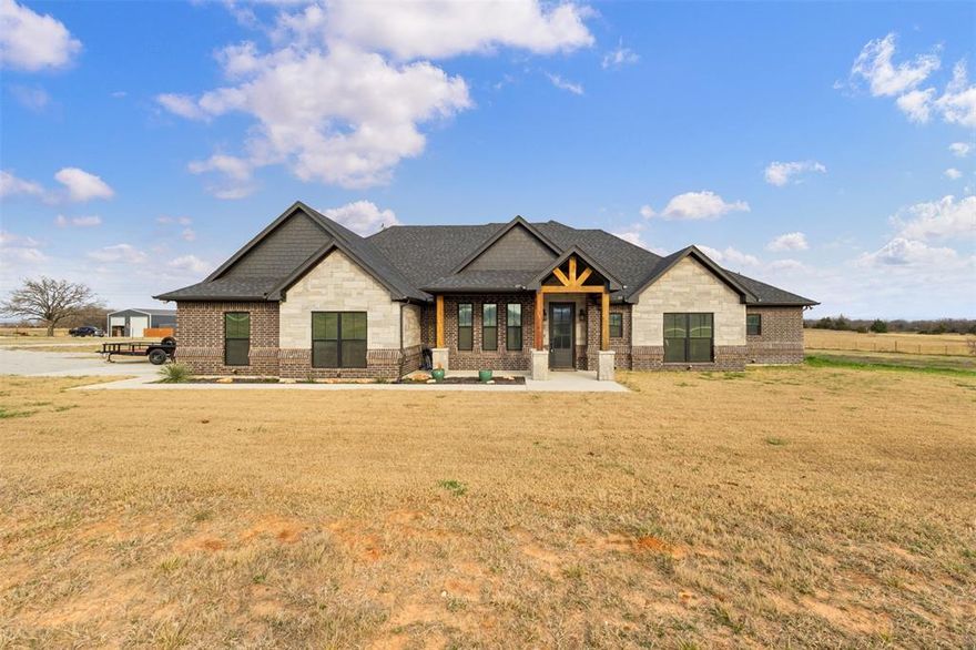 Discover a rare blend of elegance and tranquility at The Ranches of Rolling Hills, just west of Alvord, Texas. Set on five pristine acres, this custom-built 2022 residence offers nearly 2,400 sq ft of thoughtfully designed living space, including 3 spacious bedrooms and 3 full baths.
The open-concept interior features vaulted ceilings and a chef’s kitchen with a large island, farmhouse sink, electric cooktop, and double ovens—perfect for entertaining. The private primary suite boasts a spa-like bath, expansive walk-in closet, and direct access to the laundry room.
Additional highlights include an oversized garage with dedicated equipment space, a separate metal workshop, and ample room for outdoor living.
A perfect retreat for those seeking the peace of country life with the sophistication of modern comfort.