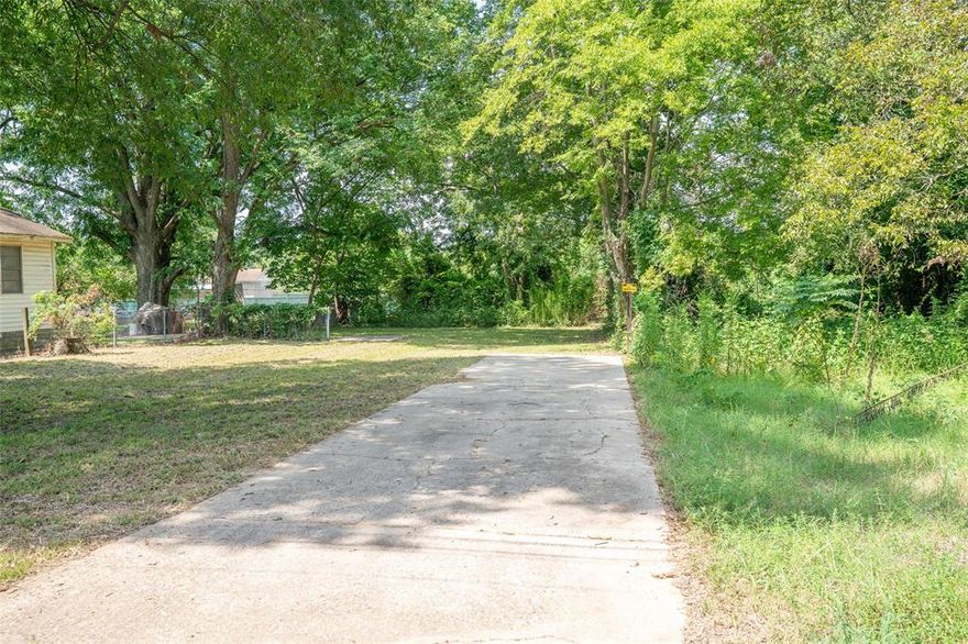 Beautiful vacant lot with  a deep back boundary on city lot with existing nice concrete driveway and beautiful trees.    Deep enough for a duplex or 3 plex.
