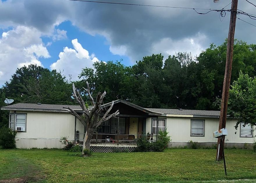 Investor Special with new price AND 5k in sellers concessions to use for repairs or closing costs! This large double wide on 3 lots needs some TLC but is livable as is. Home boasts 4 large bedrooms with split plan, 2 full bathrooms, a large utility room and 2 dining areas. The kitchen is large and has a built in office area. Back bedrooms have large closets and the master bath has a large garden tub and a stand up shower. Both front and back porches are covered. There is a detached garage on the property. Home is being sold AS IS. No repairs will be made or negotiated. The AC does not work but there are several window units. Mature trees, green grass and lots of parking make this a great location. All information deemed reliable but not guaranteed. Agent and buyer to verify all information.